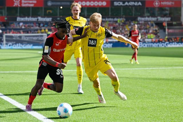 (250512) -- LEVERKUSEN, May 12, 2025 (Xinhua) -- Jeremie Frimpong (L) of Bayer 04 Leverkusen vies with Daniel Svensson of Borussia Dortmund during the first division of Bundesliga football match between Bayer 04 Leverkusen and Borussia Dortmund in Leverkusen, Germany, May 11, 2025. (Photo by Ulrich Hufnagel/Xinhua)