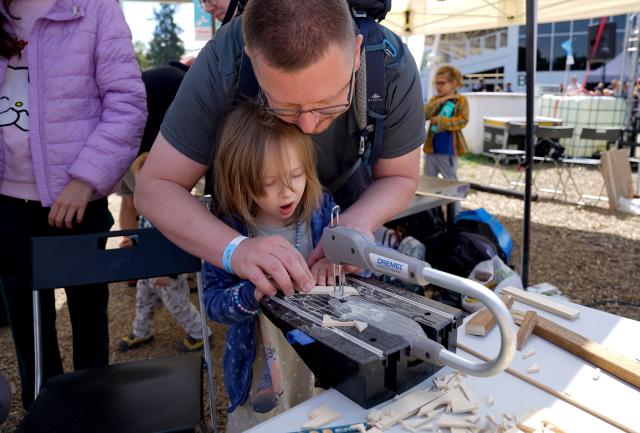 (250512) -- PRAGUE, May 12, 2025 (Xinhua) -- A man and his child cut a wooden strip with a saw during the Maker Faire Prague 2025 in Prague, the Czech Republic, May 11, 2025.
  The two-day creativity show highlights a combination of modern technology and traditional craftsmanship. (Photo by Dana Kesnerova/Xinhua)
