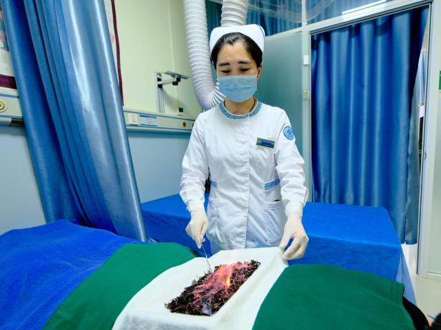 (250512) -- HOHHOT, May 12, 2025 (Xinhua) -- A nurse applies traditional tea and wine therapy of Mongolian medicine to a patient at the International Mongolian Hospital of Inner Mongolia in Hohhot, north China's Inner Mongolia Autonomous Region, May 12, 2025. The nurses of the hospital were busy at their posts on the International Nurse Day. By combining traditional Mongolian medical practices such as tea, wine and moxibustion with contemporary nursing methods, they offer patients nursing services that embodies ethnic medicine characteristics. (Xinhua/Ma Jinrui)