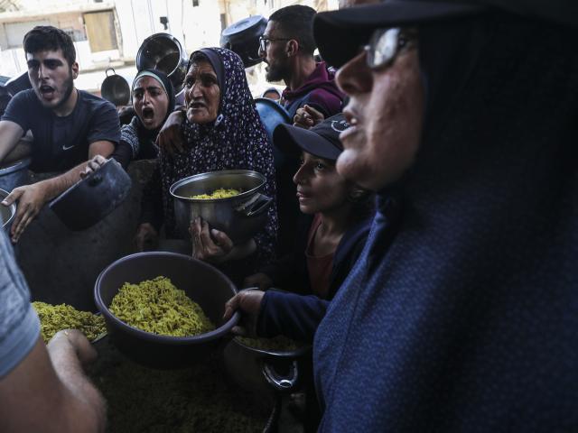 (250512) -- GAZA, May 12, 2025 (Xinhua) -- Palestinians receive free food from a food distribution center in the Jabalia refugee camp, northern Gaza Strip, May 11, 2025. (Photo by Mahmoud Zaki/Xinhua)