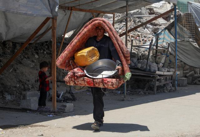 (250531) -- GAZA, May 31, 2025 (Xinhua) -- A displaced Palestinian walks on a street in Jabalia refugee camp, as he flees with his belongings from Jabalia area in northern Gaza Strip to central and western Gaza City, on May 30, 2025. (Photo by Rizek Abdeljawad/Xinhua)