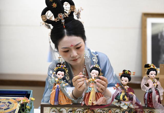(250531) -- DUNHUANG, May 31, 2025 (Xinhua) -- A woman arranges Dunhuang cultural theme exhibits after the opening ceremony of the fourth Dialogue on Exchanges and Mutual Learning among Civilizations in Dunhuang, northwest China's Gansu Province, May 30, 2025. The fourth Dialogue on Exchanges and Mutual Learning among Civilizations kicked off here on Friday. About 400 people attended the meeting, including political leaders, scholars, and heads of international organizations and non-governmental organizations from multiple countries. (Xinhua/Zhang Ling)