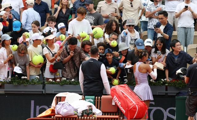 (250601) -- PARIS, June 1, 2025 (Xinhua) -- Zheng Qinwen signs autographs for supporters after the women's singles 4th round match between Liudmila Samsonova of Russia and Zheng Qinwen of China at the French Open tennis tournament at Roland Garros, Paris, France, June 1, 2025. (Xinhua/Gao Jing)