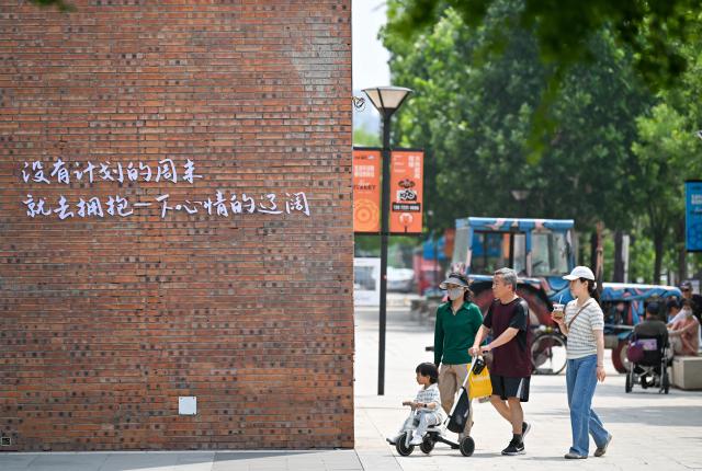 (250603) -- TIANJIN, June 3, 2025 (Xinhua) -- Citizens are seen in a renovated block at Tianjin Tractor Factory area in north China's Tianjin on May 30, 2025. Tianjin has actively implemented a renewal and upgrading program for central urban areas in recent years. A total of 40 urban renewal areas have been planned by far, focusing on the renovation of old residential areas, the protection and utilization of industrial relics and the reuse of idle assets.
   Through the urban area renewal, the city aims to improve people's living conditions, preserve and carry forward the historical heritage, promote the industrial renewal and expand new urban space, bringing vitality to the high-quality development of the region. (Xinhua/Sun Fanyue)