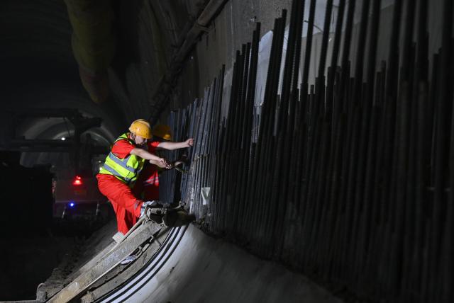 (250603) -- CHONGQING, June 3, 2025 (Xinhua) -- A worker performs his task in the Zhongliangshan tunnel, a key project along Chongqing Rail Transit Line 15, in southwest China's Chongqing Municipality, June 3, 2025. The 4,944-meter Zhongliangshan tunnel, the longest tunnel bored using the mining method in the second phase of Chongqing Rail Transit Line 15, achieved full breakthrough on Tuesday, marking a major progress in the construction of the city's first urban rail express line. (Xinhua/Chen Cheng)