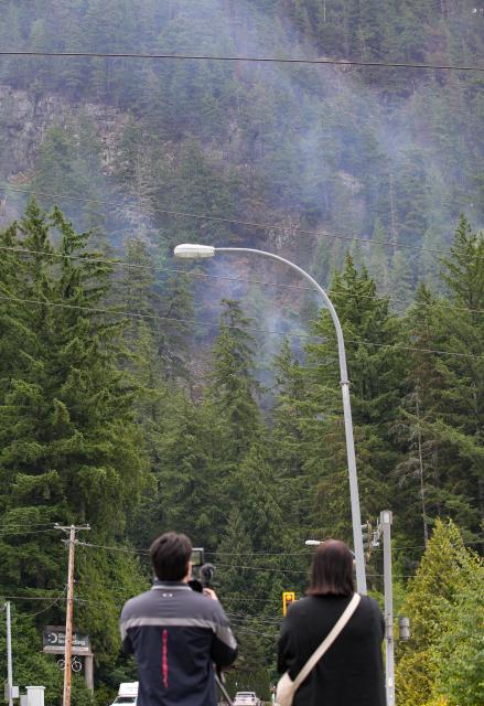 (250612) -- SQUAMISH (CANADA), June 12, 2025 (Xinhua) -- People watch the wildfire from a distance in Squamish, British Columbia, Canada, on June 12, 2025. Wildfire in Squamish has spread to 54 hectares in size, prompting an evacuation of the nearby area, according to BC Wildfire Service on Thursday. (Photo by Harrison Ha/Xinhua)