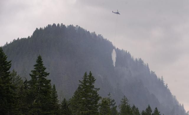 (250612) -- SQUAMISH (CANADA), June 12, 2025 (Xinhua) -- A helicopter drops water on the wildfire in Squamish, British Columbia, Canada, on June 12, 2025. Wildfire in Squamish has spread to 54 hectares in size, prompting an evacuation of the nearby area, according to BC Wildfire Service on Thursday. (Photo by Harrison Ha/Xinhua)