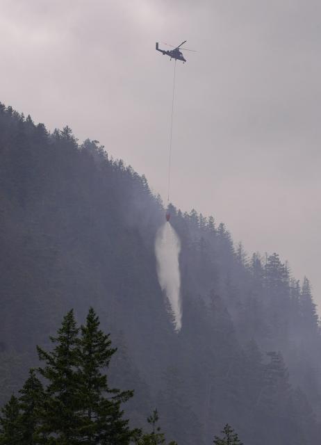 (250612) -- SQUAMISH (CANADA), June 12, 2025 (Xinhua) -- A helicopter drops water on the wildfire in Squamish, British Columbia, Canada, on June 12, 2025. Wildfire in Squamish has spread to 54 hectares in size, prompting an evacuation of the nearby area, according to BC Wildfire Service on Thursday. (Photo by Harrison Ha/Xinhua)