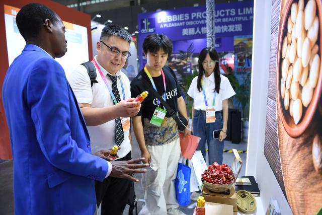 (250613) -- BEIJING, June 13, 2025 (Xinhua) -- An exhibitor introduces Rwandan chili sauce products during the 4th China-Africa Economic and Trade Expo in Changsha, central China's Hunan Province, June 12, 2025. At the ongoing 4th China-Africa Economic and Trade Expo held in Changsha of Hunan, a chili sauce product, made from Rwandan peppers, has received great consumer attention for its strong flavor. The rise of the chili sauce is a clear sign of a growing bond between African farms and Chinese consumers. 
  Dating back to the 1st China-Africa Economic and Trade Expo in 2019, enterprises in Hunan made a preliminary agreement with their Rwandan counterparts to purchase dried peppers, following an export application of dried peppers from Rwanda to China. In August 2021, Rwanda exported dried peppers to Hunan for the first time and became the first African country exporting dried peppers to China. 
  In 2024, Gashora Farm, which is headquartered in Kigali, the capital of Rwanda, partnered with HAIC -- Hunan Modern Agriculture International Development Co. Ltd, a subsidiary of Hunan Cereals, Oils & Foodstuffs Import & Export Group (Hunan COF) -- to launch the Rwanda-Hunan Chili Pepper Industry Demonstration Project. Rwanda's favorable climate, affordable labor force, and efficient government procedures facilitated the project's growth. 
   Under a contract farming model, the project covers 100 hectares and spans the entire value chain -- from seedling cultivation to export. In the first season after the deal was signed, 200 tons of dried chili were shipped to China.
  The Rwandan chili project crystalizes deepening Africa-China cooperation. Across the Asian and African continents, stories of trust, cooperation, and shared growth continue to get written. (Xinhua/Jin Mamengni)