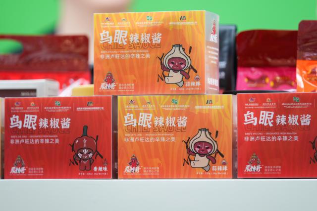 (250613) -- BEIJING, June 13, 2025 (Xinhua) -- This photo taken on June 5, 2025 shows Rwandan chili sauce products at the Hunan Cereals, Oils & Foodstuffs Import & Export Group in central China's Hunan Province. At the ongoing 4th China-Africa Economic and Trade Expo held in Changsha of Hunan, a chili sauce product, made from Rwandan peppers, has received great consumer attention for its strong flavor. The rise of the chili sauce is a clear sign of a growing bond between African farms and Chinese consumers. 
  Dating back to the 1st China-Africa Economic and Trade Expo in 2019, enterprises in Hunan made a preliminary agreement with their Rwandan counterparts to purchase dried peppers, following an export application of dried peppers from Rwanda to China. In August 2021, Rwanda exported dried peppers to Hunan for the first time and became the first African country exporting dried peppers to China. 
  In 2024, Gashora Farm, which is headquartered in Kigali, the capital of Rwanda, partnered with HAIC -- Hunan Modern Agriculture International Development Co. Ltd, a subsidiary of Hunan Cereals, Oils & Foodstuffs Import & Export Group (Hunan COF) -- to launch the Rwanda-Hunan Chili Pepper Industry Demonstration Project. Rwanda's favorable climate, affordable labor force, and efficient government procedures facilitated the project's growth. 
   Under a contract farming model, the project covers 100 hectares and spans the entire value chain -- from seedling cultivation to export. In the first season after the deal was signed, 200 tons of dried chili were shipped to China.
  The Rwandan chili project crystalizes deepening Africa-China cooperation. Across the Asian and African continents, stories of trust, cooperation, and shared growth continue to get written. (Xinhua/Chen Zeguo)
