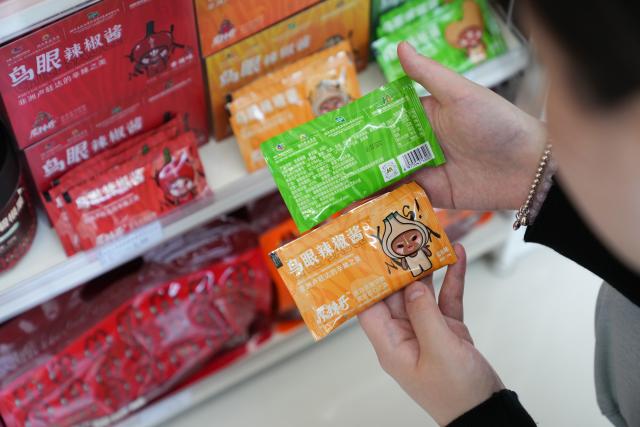 (250613) -- BEIJING, June 13, 2025 (Xinhua) -- A consumer chooses Rwandan chili sauce products at a convenient store in Changsha, central China's Hunan Province, June 6, 2025. At the ongoing 4th China-Africa Economic and Trade Expo held in Changsha of Hunan, a chili sauce product, made from Rwandan peppers, has received great consumer attention for its strong flavor. The rise of the chili sauce is a clear sign of a growing bond between African farms and Chinese consumers. 
  Dating back to the 1st China-Africa Economic and Trade Expo in 2019, enterprises in Hunan made a preliminary agreement with their Rwandan counterparts to purchase dried peppers, following an export application of dried peppers from Rwanda to China. In August 2021, Rwanda exported dried peppers to Hunan for the first time and became the first African country exporting dried peppers to China. 
  In 2024, Gashora Farm, which is headquartered in Kigali, the capital of Rwanda, partnered with HAIC -- Hunan Modern Agriculture International Development Co. Ltd, a subsidiary of Hunan Cereals, Oils & Foodstuffs Import & Export Group (Hunan COF) -- to launch the Rwanda-Hunan Chili Pepper Industry Demonstration Project. Rwanda's favorable climate, affordable labor force, and efficient government procedures facilitated the project's growth. 
   Under a contract farming model, the project covers 100 hectares and spans the entire value chain -- from seedling cultivation to export. In the first season after the deal was signed, 200 tons of dried chili were shipped to China.
  The Rwandan chili project crystalizes deepening Africa-China cooperation. Across the Asian and African continents, stories of trust, cooperation, and shared growth continue to get written. (Xinhua/Chen Zeguo)