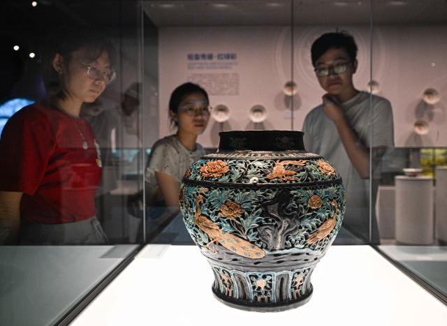 (250614) -- QIONGHAI, June 14, 2025 (Xinhua) -- Visitors look at a jar displayed at the China (Hainan) Museum of the South China Sea in Qionghai, south China's Hainan Province, June 12, 2025. A great number of exhibits relevant to the Maritime Silk Road are showcased at the China (Hainan) Museum of the South China Sea, providing valuable insights into the prosperity of the Maritime Silk Road in ancient China and the exchanges between Chinese and foreign civilizations. (Xinhua/Pu Xiaoxu)