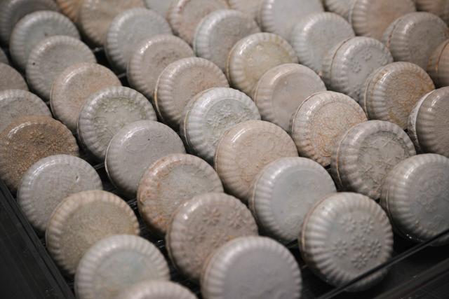 (250614) -- QIONGHAI, June 14, 2025 (Xinhua) -- This photo taken on June 12, 2025 shows the bluish-white-glazed powder boxes decorated with chrysanthemum pattern displayed at the China (Hainan) Museum of the South China Sea in Qionghai, south China's Hainan Province. A great number of exhibits relevant to the Maritime Silk Road are showcased at the China (Hainan) Museum of the South China Sea, providing valuable insights into the prosperity of the Maritime Silk Road in ancient China and the exchanges between Chinese and foreign civilizations. (Xinhua/Pu Xiaoxu)