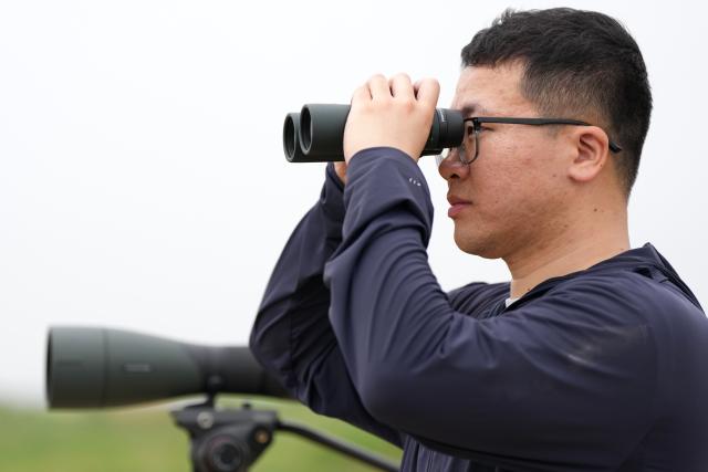 (250614) -- YANCHENG, June 14, 2025 (Xinhua) -- Gu Jialin observes birds at the Jiangsu Yancheng Wetlands and Rare Birds National Nature Reserve in Yancheng, east China's Jiangsu Province, June 7, 2025. Gu Jialin, 27, is the head of the Tinghu management station under the reserve's administration office. He is in charge of wetland conservation and management. The Jiangsu Yancheng Wetlands and Rare Birds National Nature Reserve is located on the coast of the Yellow Sea. It serves as a sanctuary for rare and endangered wildlife, particularly the red-crowned crane, and protects the vital tidal wetland ecosystem on which these animals depend. 
  Here, a dedicated group of young professionals work tirelessly in wildlife rescue, ecological monitoring, and the management of wetlands. With passion and expertise, they safeguard both the animals and their habitats. (Xinhua/Li Yibo)