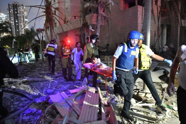 (250617) -- BEIJING, June 17, 2025 (Xinhua) -- Israeli security and rescue forces evacuate a woman at the site of an Iranian missile attack in Petah Tikva, central Israel, on June 16, 2025.
  Iran launched a new pre-dawn missile attack on Israel on Monday, killing at least eight people and wounding dozens, Israeli officials said, as the four-day conflict triggered by an Israeli surprise assault intensified. (JINI via Xinhua)
