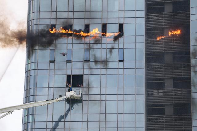 (250625) -- SHENZHEN, June 25, 2025 (Xinhua) -- Firefighters evacuate mock trapped persons during a fire drill for a high-rise building in Shenzhen, south China's Guangdong Province, June 24, 2025. A high-rise building fire drill aimed at testing the efficiency of high-tech firefighting methods and improving response time was held here on Tuesday. (Xinhua/Mao Siqian)