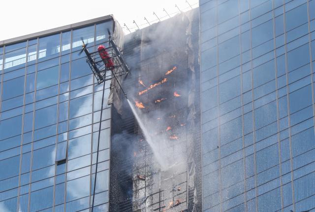 (250625) -- SHENZHEN, June 25, 2025 (Xinhua) -- A drone releases fire extinguishing agent during a fire drill for a high-rise building in Shenzhen, south China's Guangdong Province, June 24, 2025. A high-rise building fire drill aimed at testing the efficiency of high-tech firefighting methods and improving response time was held here on Tuesday. (Xinhua/Mao Siqian)