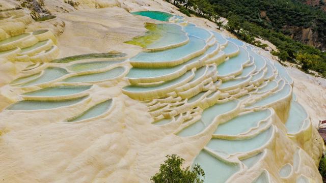 (250627) -- DEQEN, June 27, 2025 (Xinhua) -- An aerial drone photo shows a view of Baishuitai in Sanba Township, Shangri-la, the Deqen Tibetan Autonomous Prefecture, southwest China's Yunnan Province, June 26, 2025. Formed by the sediments of high calcium carbonate in spring waters, Baishuitai is one of the biggest limestone terraces in China. (Xinhua/Pu Chao)