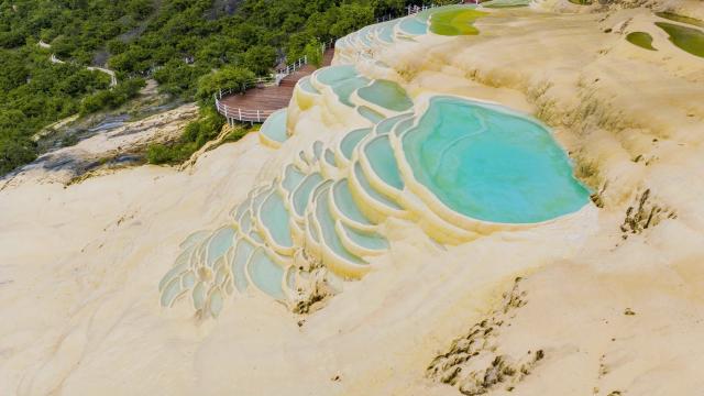 (250627) -- DEQEN, June 27, 2025 (Xinhua) -- An aerial drone photo shows a view of Baishuitai in Sanba Township, Shangri-la, the Deqen Tibetan Autonomous Prefecture, southwest China's Yunnan Province, June 26, 2025. Formed by the sediments of high calcium carbonate in spring waters, Baishuitai is one of the biggest limestone terraces in China. (Xinhua/Pu Chao)