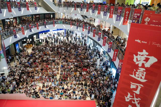 (250630) -- BEIJING, June 30, 2025 (Xinhua) -- Fans watch the 2025 Jiangsu Football City League (JSCL) live match on a giant screen inside a shopping mall in Nantong, east China's Jiangsu Province, June 29, 2025. (Xinhua/Li Bo)