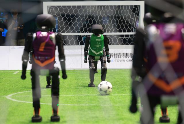 (250630) -- BEIJING, June 30, 2025 (Xinhua) -- A robot player (C) of the Mountain Sea team from China Agricultural University competes during an AI-powered robot football match in Beijing, capital of China, June 28, 2025. (Xinhua/Zhang Chenlin)