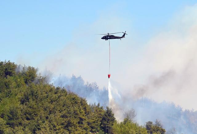 (250630) -- IZMIR (TÜRKIYE), June 30, 2025 (Xinhua) -- A helicopter puts out a fire in the Seferihisar district of Izmir, Türkiye, on June 30, 2025. Türkiye has evacuated more than 50,000 people from regions affected by forest fires across the country, with the western province of Izmir accounting for the majority of evacuations, the country's disaster agency said on Monday. (Mustafa Kaya/Handout via Xinhua)