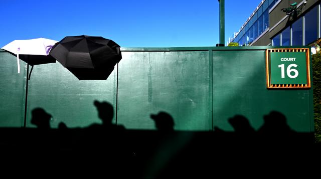 (250701) -- LONDON, July 1, 2025 (Xinhua) -- Spectators' shadows are cast on a court fencing on the opening day of the Wimbledon Championships in London, Britain, June 30, 2025. Tennis fans faced the hottest start to Wimbledon on record on Monday as temperature soared to 32 degrees Celsius. (Xinhua/Li Ying)