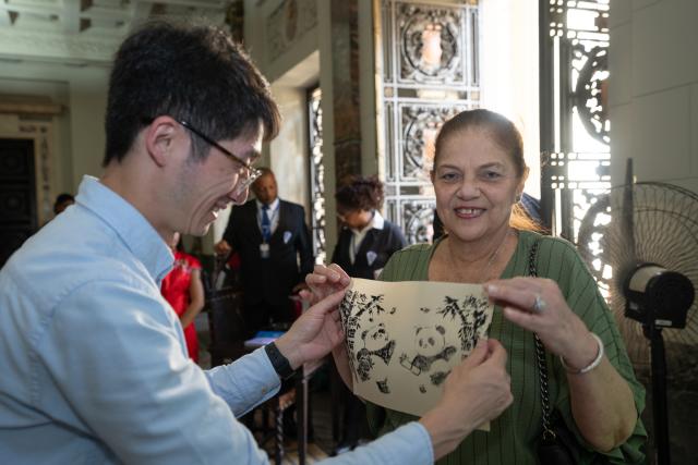 (250701) -- RIO DE JANEIRO, July 1, 2025 (Xinhua) -- A visitor shows an imprint work during an exposition of innovation in traditional craftsmanship of the east China's city of Hangzhou at Tiradentes Palace in Rio de Janeiro, Brazil, June 30, 2025. The event showcased a variety of Chinese traditional crafts and their innovative expressions to the Brazilian public through demonstrations and interactive experiences. (Xinhua/Wang Tiancong)