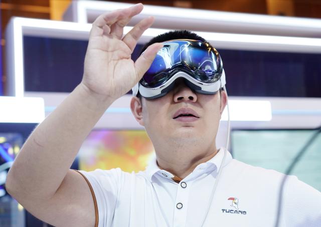 (250702) -- BEIJING, July 2, 2025 (Xinhua) -- A visitor tries an MR device at an exhibition area of the 2025 Global Digital Economy Conference in Beijing, capital of China, July 2, 2025. With the theme "Building a Digital-Friendly City", the 2025 Global Digital Economy Conference opened here on Wednesday. (Xinhua/Zhang Chenlin)
