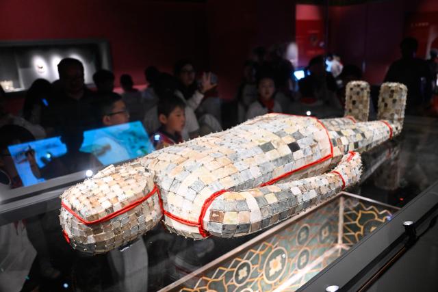 (250702) -- XUYI, July 2, 2025 (Xinhua) -- This photo taken on July 2, 2025 shows a jade suit with gold strings at a museum featuring Han Dynasty (202 BC-220 AD) tombs in Xuyi, east China's Jiangsu Province. The museum of Han king's mausoleum at Dayun Mountain in Xuyi stages several featured exhibitions in this summer holiday to attract people to visit and learn about history knowledge. (Xinhua/Ji Chunpeng)