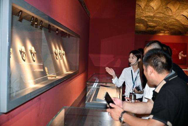 (250702) -- XUYI, July 2, 2025 (Xinhua) -- A tour guide introduces cultural relics to visitors at a museum featuring Han Dynasty (202 BC-220 AD) tombs in Xuyi, east China's Jiangsu Province, July 2, 2025. The museum of Han king's mausoleum at Dayun Mountain in Xuyi stages several featured exhibitions in this summer holiday to attract people to visit and learn about history knowledge. (Xinhua/Ji Chunpeng)