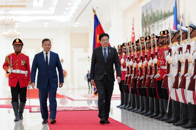 (250702) -- PHNOM PENH, July 2, 2025 (Xinhua) -- Cambodian Prime Minister Hun Manet (2nd, L) and Singaporean Prime Minister Lawrence Wong (3rd, L) inspect the guard of honor at the Peace Palace in Phnom Penh, Cambodia, July 2, 2025. Cambodia and Singapore on Wednesday vowed to further boost bilateral relations and cooperation.
The commitment was made during a meeting between Cambodian Prime Minister Hun Manet and his visiting Singaporean counterpart Lawrence Wong in Phnom Penh, said a news release from the Cambodian prime minister's spokesperson unit. (Photo by Nitola/Xinhua)