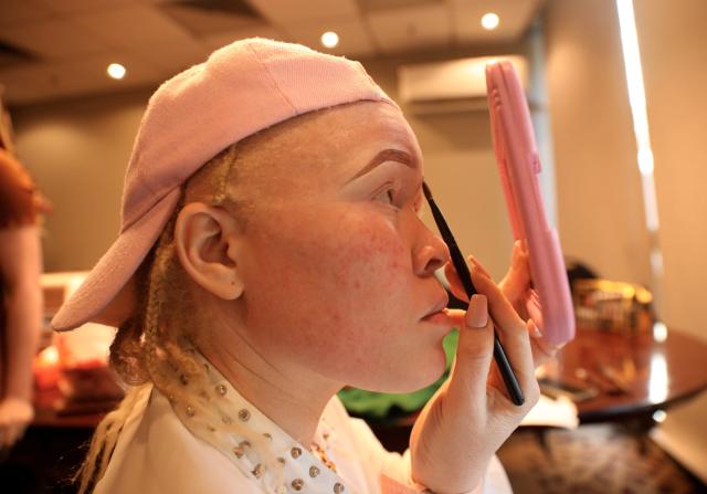 (250702) -- HARARE, July 2, 2025 (Xinhua) -- A contestant puts on makeup before the inaugural Mr and Miss Albinism Africa 2025 pageant in Harare, Zimbabwe, June 28, 2025. TO GO WITH "Feature: African models inspire people with albinism to defy prejudice" (Photo by Shaun Jusa/Xinhua)
