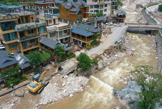 (250703) -- BEIJING, July 3, 2025 (Xinhua) -- An aerial drone photo taken on July 2, 2025 shows an excavator clearing the road in Taiping Town of Xixia County, Nanyang City, central China's Henan Province. Torrential downpours in Taiping and Erlangping triggered a sudden surge in the water level in the downstream of a local river in Xixia County on Monday, damaging infrastructure and leaving some residents trapped.
  Following the flooding, rescue efforts were immediately implemented, with two people successfully rescued. Further search and rescue efforts are underway in the quest to locate the three missing individuals. (Xinhua/Hao Yuan)