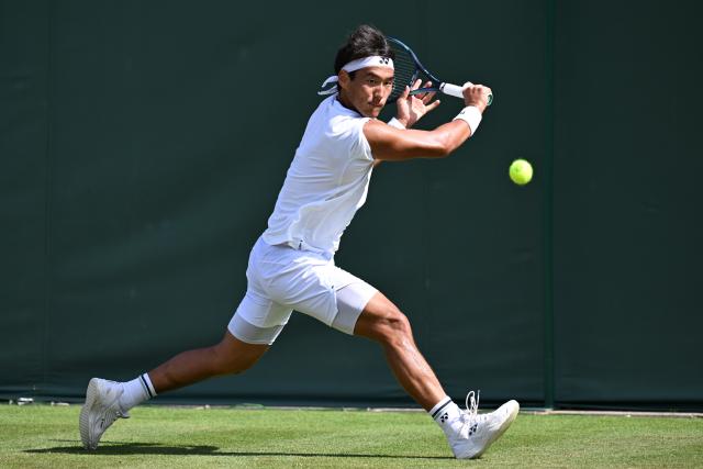 (250703) -- LONDON, July 3, 2025 (Xinhua) -- Bu Yunchaokete hits a return during the men's singles first round match between Bu Yunchaokete of China and Nakashima Brandon of the United States at the Wimbledon Tennis Championships in London, Britain, July 2, 2025. (Xinhua/Zhao Dingzhe)