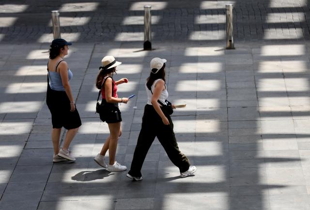 (250703) -- SEVILLE, July 3, 2025 (Xinhua) -- People walk amid the heatwave in Seville, Spain, July 2, 2025. Spain continues to endure a record-breaking heatwave. More than 100 monitoring stations of the Spanish meteorological agency AEMET registered temperatures exceeding 40 degrees Celsius during the first major heatwave of the year. (Xinhua/Li Jing)