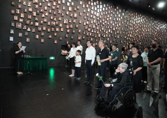(250703) -- NANJING, July 3, 2025 (Xinhua) -- People attend a "lights out" ceremony held at the Memorial Hall of the Victims in Nanjing Massacre by Japanese Invaders, in Nanjing, east China's Jiangsu Province, July 2, 2025. A "lights out" ceremony for two survivors of the Nanjing Massacre who passed away this year was held here on Wednesday. On a photo wall featuring survivors of the Nanjing Massacre, the lightboxes of Liu Guixiang and Xie Guiying were dimmed off, and their colored photos then turned to black and white.
   With the passing away of Liu and Xie earlier this year, the number of living registered survivors has decreased to 26. (Photo by Liu Zhenrui/Xinhua)
