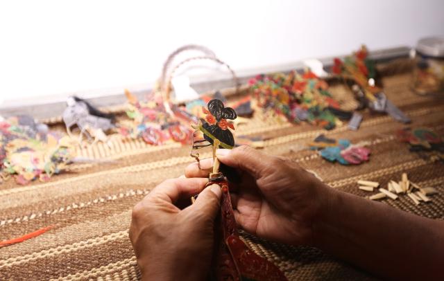 (250703) -- TONGWEI, July 3, 2025 (Xinhua) -- Liu Mancang prepares to perform shadow puppet show in Changjiahe Town of Tongwei County, northwest China's Gansu Province, July 1, 2025. After harvesting his own wheat, Liu Mancang, an inheritor of the national intangible cultural heritage project Tongwei Shadow Puppetry, began traveling through the village to perform shadow play for his fellow villagers in Changjiahe Town, Tongwei County, making the most of his leisure time during the farming off season.
   Tongwei Shadow Puppetry is widely spread across Dingxi, Tianshui and Longnan in Gansu Province. It is a folk drama in which animal skins or cardboard are made into silhouettes to perform stories. 
   Liu, now 60, began to learn shadow puppetry from his grandfather at the age of 12. After decades of study, he has mastered the skills of shadow puppetry proficiently and collected and sorted out over a hundred shadow puppetry scripts. In 2018, he was recognized as an inheritor of Tongwei Shadow Puppetry.
   Liu has visited and studied in provinces like Shaanxi, Henan and Guangdong. While improving his own skills, he also promoted Tongwei Shadow Puppetry through voluntary performances in schools, hoping that this ancient folk art would shine with new luster. (Photo by Wang Kexian/Xinhua)