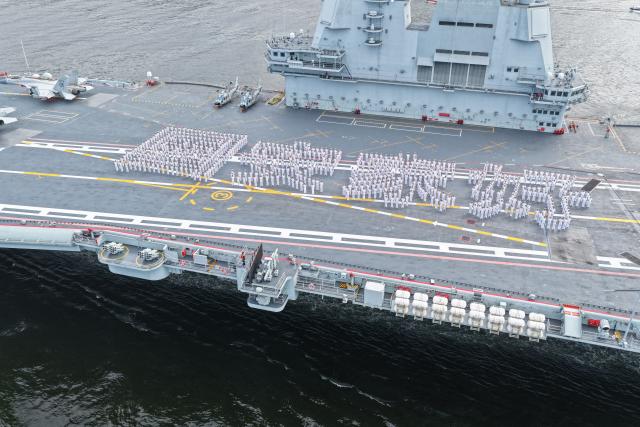 (250703) -- HONG KONG, July 3, 2025 (Xinhua) -- A drone photo shows officers and soldiers spelling out Chinese characters "secure country, sweet home" on aircraft carrier Shandong's flight deck in Hong Kong waters, south China, July 3, 2025. A fleet of the Chinese People's Liberation Army (PLA) Navy led by the aircraft carrier Shandong arrived in the Hong Kong Special Administrative Region (HKSAR) on Thursday morning, kicking off a five-day visit.
   The aircraft carrier and the Yan'an missile destroyer were anchored near the west end of the Victoria Harbor, while the Zhanjiang missile destroyer and the Yuncheng missile frigate docked at the PLA Hong Kong Garrison's naval base in Stonecutters Island.
   This is the Shandong's first visit to Hong Kong. From Friday to Sunday, the Shandong, the Zhanjiang and the Yuncheng will host open tours, lectures, drill demonstrations and other exchange activities. (Photo by Pu Haiyang/Xinhua)