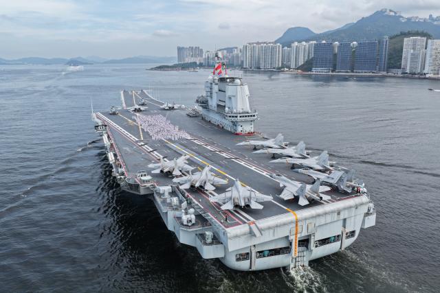 (250703) -- HONG KONG, July 3, 2025 (Xinhua) -- A drone photo shows officers and soldiers spelling out Chinese characters "secure country, sweet home" on aircraft carrier Shandong's flight deck in Hong Kong waters, south China, July 3, 2025. A fleet of the Chinese People's Liberation Army (PLA) Navy led by the aircraft carrier Shandong arrived in the Hong Kong Special Administrative Region (HKSAR) on Thursday morning, kicking off a five-day visit.
   The aircraft carrier and the Yan'an missile destroyer were anchored near the west end of the Victoria Harbor, while the Zhanjiang missile destroyer and the Yuncheng missile frigate docked at the PLA Hong Kong Garrison's naval base in Stonecutters Island.
   This is the Shandong's first visit to Hong Kong. From Friday to Sunday, the Shandong, the Zhanjiang and the Yuncheng will host open tours, lectures, drill demonstrations and other exchange activities. (Photo by Pu Haiyang/Xinhua)