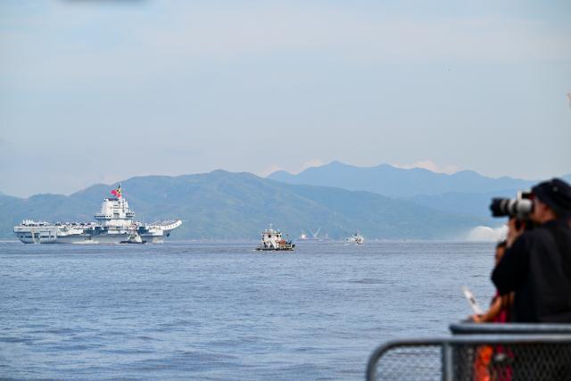 (250703) -- HONG KONG, July 3, 2025 (Xinhua) -- People take photos as the aircraft carrier Shandong arrives in Hong Kong waters, south China, July 3, 2025. A fleet of the Chinese People's Liberation Army (PLA) Navy led by the aircraft carrier Shandong arrived in the Hong Kong Special Administrative Region (HKSAR) on Thursday morning, kicking off a five-day visit.
   The aircraft carrier and the Yan'an missile destroyer were anchored near the west end of the Victoria Harbor, while the Zhanjiang missile destroyer and the Yuncheng missile frigate docked at the PLA Hong Kong Garrison's naval base in Stonecutters Island.
   This is the Shandong's first visit to Hong Kong. From Friday to Sunday, the Shandong, the Zhanjiang and the Yuncheng will host open tours, lectures, drill demonstrations and other exchange activities. (Xinhua/Zhu Wei)