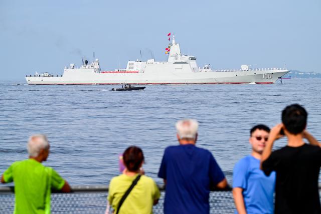 (250703) -- HONG KONG, July 3, 2025 (Xinhua) -- People watch as the aircraft carrier Shandong arrives in Hong Kong waters, south China, July 3, 2025. A fleet of the Chinese People's Liberation Army (PLA) Navy led by the aircraft carrier Shandong arrived in the Hong Kong Special Administrative Region (HKSAR) on Thursday morning, kicking off a five-day visit.
   The aircraft carrier and the Yan'an missile destroyer were anchored near the west end of the Victoria Harbor, while the Zhanjiang missile destroyer and the Yuncheng missile frigate docked at the PLA Hong Kong Garrison's naval base in Stonecutters Island.
   This is the Shandong's first visit to Hong Kong. From Friday to Sunday, the Shandong, the Zhanjiang and the Yuncheng will host open tours, lectures, drill demonstrations and other exchange activities. (Xinhua/Zhu Wei)