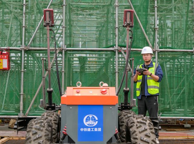 (250703) -- CHONGQING, July 3, 2025 (Xinhua) -- This photo taken on April 27, 2023 shows a technician with China Railway Construction Engineering Group operates a four-wheel screed machine at the construction site of Chongqing East Railway Station in southwest China's Chongqing. As the new section of the Chongqing-Xiamen high-speed railway, from Chongqing to Qianjiang, officially opened a week ago, the key hub along this route, Chongqing East Railway Station, was also put into operation.
   From obtaining the design blueprints in May 2022 to its official inauguration, it has taken 38 months to complete what is now the largest high-speed rail station in west China. Behind this monumental construction project are a group of unsung heroes -- robots.
   TO GO WITH "China Focus: A robot revolution in building the largest railway station in west China" (China Railway Construction Engineering Group/Handout via Xinhua)