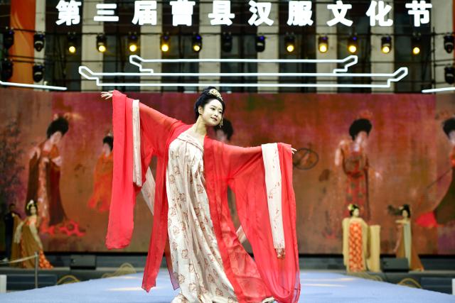 (250703) -- HEZE, July 3, 2025 (Xinhua) -- A model presents Hanfu on the stage during a Hanfu launch event in Caoxian County of Heze City, east China's Shandong Province, April 10, 2025. The Yellow River, which flows through Heze, not only shapes the hallmark of the city in central China, but also nurtures the peonies with beauty and fragrance, creating a flower city with water charm.
  As the "peony capital of China", the peony planting in Heze can be traced back to the Sui and Tang dynasties (581-907). At present, the city has bred 1,308 varieties of peonies. (Xinhua/Guo Xulei)