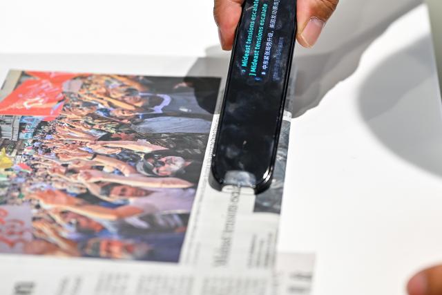 (250703) -- HEFEI, July 3, 2025 (Xinhua) -- A visitor experiences the translation function of a dictionary pen at the artificial intelligence experience hall of iFLYTEK in Hefei, east China's Anhui Province, July 2, 2025. In alignment with the national strategy to cultivate industries of the future, Hefei is forging ahead with strategic layouts in emerging frontiers like quantum information, low-altitude economy, commercial aerospace, fusion energy, artificial intelligence, intelligent robotics, and biosynthetic manufacturing to accelerate industrial cluster formation. The city has achieved remarkable progress across multiple future industry sectors, emerging as a robust hub of rapid advancement. (Xinhua/Zhang Cheng)
