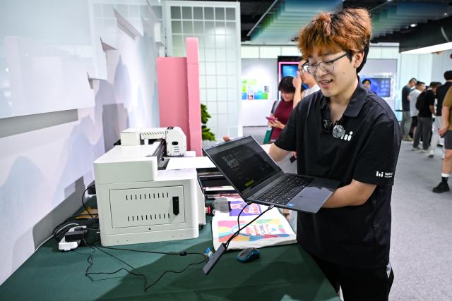 (250703) -- HEFEI, July 3, 2025 (Xinhua) -- A staff member introduces the AI text-to-image generation function of HiDream.ai, a high-tech startup focusing on generative intelligence for creativity, in Hefei, east China's Anhui Province, July 2, 2025. In alignment with the national strategy to cultivate industries of the future, Hefei is forging ahead with strategic layouts in emerging frontiers like quantum information, low-altitude economy, commercial aerospace, fusion energy, artificial intelligence, intelligent robotics, and biosynthetic manufacturing to accelerate industrial cluster formation. The city has achieved remarkable progress across multiple future industry sectors, emerging as a robust hub of rapid advancement. (Xinhua/Zhang Cheng)