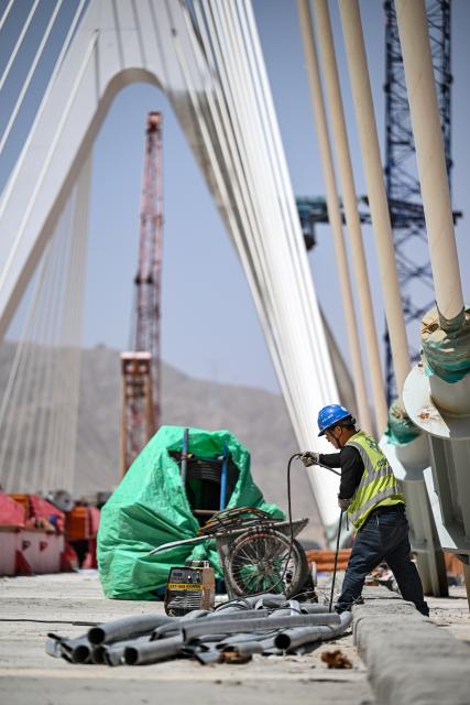 (250703) -- ZHONGWEI, July 3, 2025 (Xinhua) -- A constructor works at the construction site of the Heishan Gorge Yellow River grand bridge in Zhongwei City, northwest China's Ningxia Hui Autonomous Region, July 3, 2025. The two sides of the Heishan Gorge Yellow River grand bridge were joined together on Thursday, laying a solid foundation for the bridge's completion within this year.
  The 1,539-meter-long grand bridge, with a span of 240 meters, is a major project of the highway linking Zhongwei of northwest China's Ningxia Hui Autonomous Region and Mengjiawan of northwest China's Shaanxi Province. (Xinhua/Feng Kaihua)