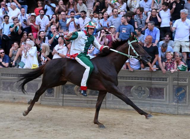 (250704) -- SIENA, July 4, 2025 (Xinhua) -- Palio jockey Giovanni Atzeni, also known as "Tittia", celebrates after winning the Palio in Siena, Italy, July 3, 2025. Palio in Siena, or "Palio di Siena" in Italian, is a historical horse race held twice a year in Siena since 1656. (Photo by Alberto Lingria/Xinhua)