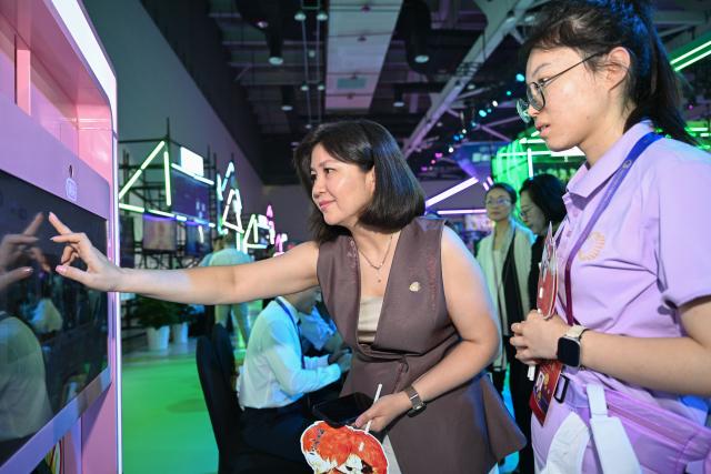 (250704) -- CHONGQING, July 4, 2025 (Xinhua) -- A guest interacts with an exhibit at the Yongchuan International Convention and Exhibition Center in southwest China's Chongqing, July 4, 2025. The 2025 SCO (the Shanghai Cooperation Organization) Film Festival takes place from July 3 to 7 here, attracting filmmakers from Russia, Belarus, Pakistan and other SCO member states to present their country's films. The event also gathered over 40 domestic film enterprises to present the latest advancements in film technology and production. 
Highlighting the latest advancements in film technology and production across member states, the event features 11 major activities, including film screenings, cooperation forums, a film technology exhibition, and a gala concert. (Xinhua/Chen Cheng)