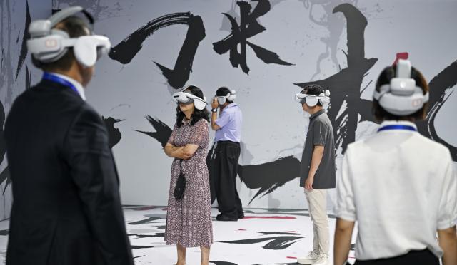 (250704) -- CHONGQING, July 4, 2025 (Xinhua) -- Guests enjoy VR films at the Yongchuan International Convention and Exhibition Center in southwest China's Chongqing, July 4, 2025. The 2025 SCO (the Shanghai Cooperation Organization) Film Festival takes place from July 3 to 7 here, attracting filmmakers from Russia, Belarus, Pakistan and other SCO member states to present their country's films. The event also gathered over 40 domestic film enterprises to present the latest advancements in film technology and production. 
Highlighting the latest advancements in film technology and production across member states, the event features 11 major activities, including film screenings, cooperation forums, a film technology exhibition, and a gala concert. (Xinhua/Chen Cheng)
